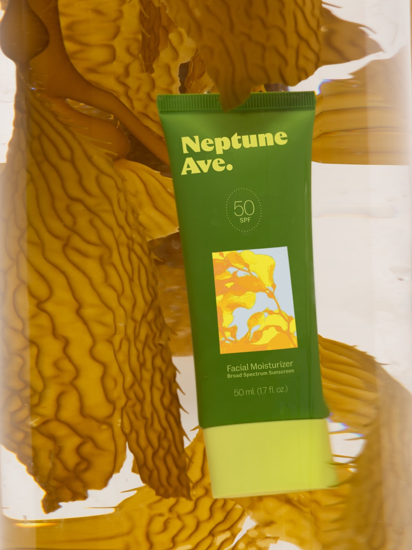 Neptune Ave. SPF 50 sunscreen surrounded by kelp in amber liquid